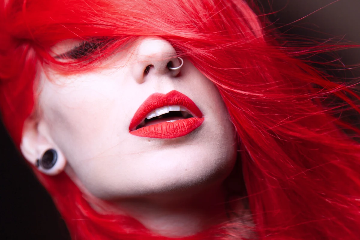 close-up of woman's face with red hair and red lisptick
